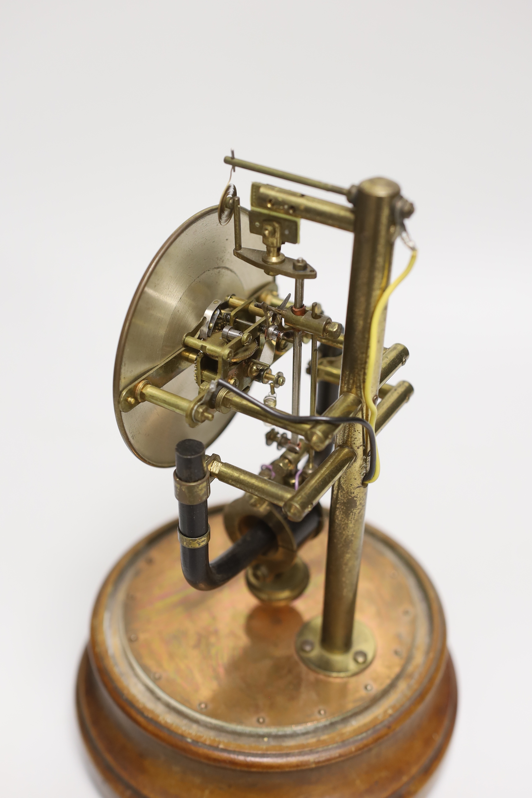 A Pinchin Johnson 800 day electric timepiece, under a glass dome, raised on a circular wood base, 26cm high